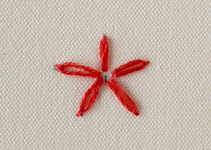 Bordado básico de flor de margarita perezosa con hilo dental rojo