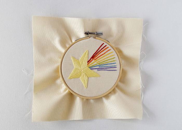 Frame the fabric with your embroidery centered in a hoop and tighten the screw.