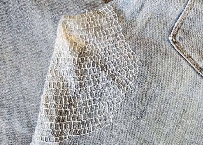 Idée de raccommodage : Denim raccommodé avec un jean bleu clair rempli de points de feston