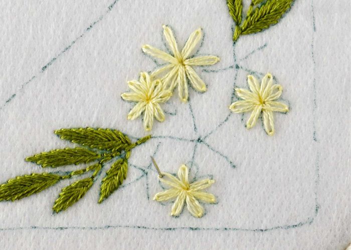 Petites marguerites brodées avec du fil jaune clair